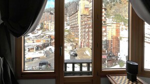 A room with a large window overlooking a snowy mountain town, a wooden desk, and a chessboard. - Renovated apartment for 4 in Avoriaz with wifi (Avoriaz)