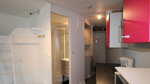 A compact kitchen with white cabinets, a red refrigerator, and a small stool. - Renovated apartment for 4 in Avoriaz with wifi (Avoriaz)