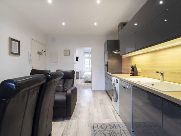 Una cocina moderna con horno integrado, un lavabo y una cafetera.