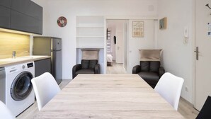 Apartamento moderno com cozinha, sala de jantar e duas áreas de estar.