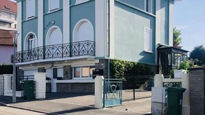 A two-story building with a balcony, a gated entrance, and a trash bin. - Jade (Vittel)