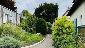 A residential street with houses on either side, a curved driveway, and lush greenery. - Chalet de Romy (Vittel)