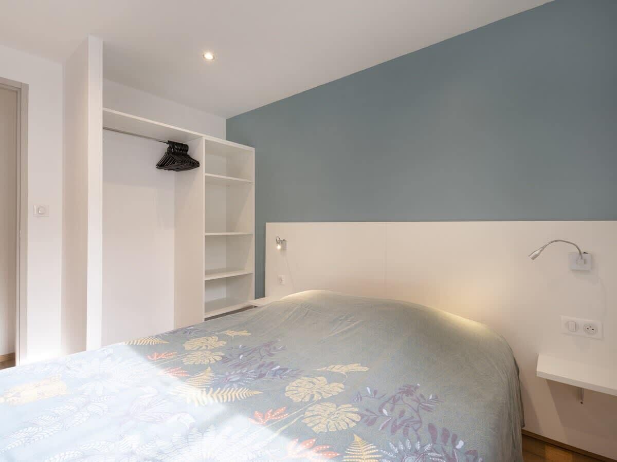 Ein Schlafzimmer mit Bett, Schrank und Nachttisch.