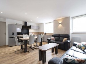 Een modern appartement met een keuken, eethoek en woonkamer.
