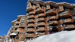 A multi-story hotel with a unique architectural design featuring brickwork and balconies. - Cozy studio in Avoriaz for 2 pers with Wifi (Avoriaz)
