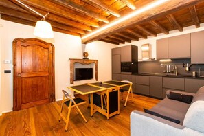 Une cuisine compacte dotée d’appareils électroménagers modernes, une table à manger en bois et un coin salon confortable.
