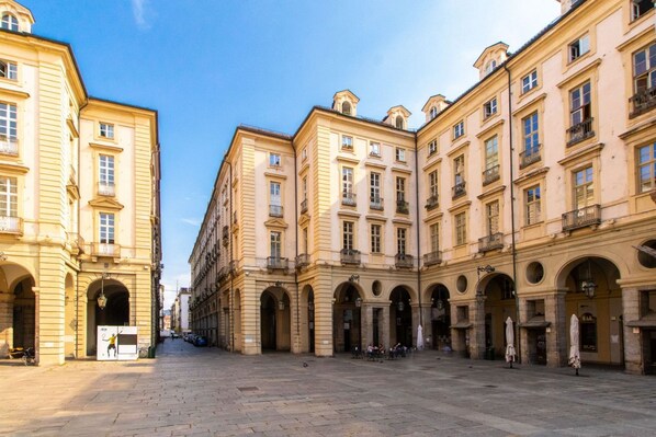 A historic square with classical architecture, featuring a central open space surrounded by buildings with balconies and arched windows. - GuestHost - Our wonderful apartment is located in the historic center of Turin, overlooking the rooftops of the Quadrilatero Romano. The house is equipped with every comfort and is perfect for 6 people. The apartment is situated very close to all the mai (Torino)