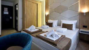 A hotel room with a large bed, two bedside tables, a wardrobe, and a blue chair. - Hotel Sumadija (Belgrade)
