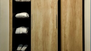 A wooden wardrobe with a built-in shelf containing folded towels. - Hotel Sumadija (Belgrade)