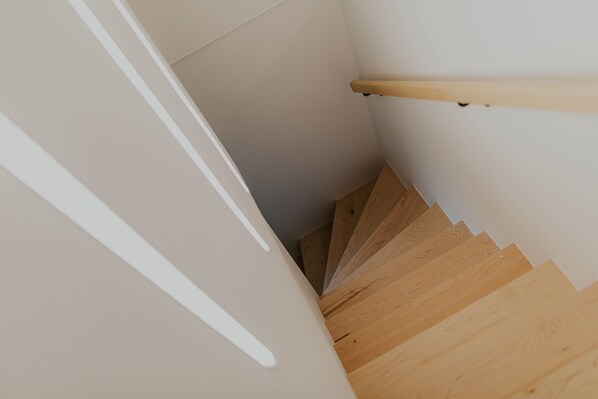 A wooden staircase with a handrail and a white wall. - Haloze hills in your hand (Cirkulane)