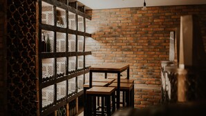A room with a brick wall, wooden shelves, and tables. - Haloze hills in your hand (Cirkulane)