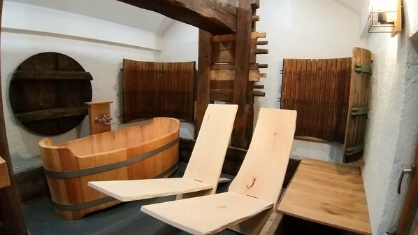 A wooden sauna with a large tub, two wooden chairs, and a wooden bench. - Haloze hills in your hand (Cirkulane)