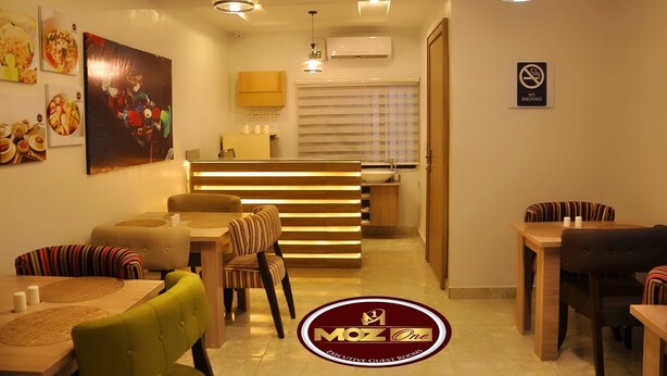 A modern dining area with a reception desk, striped chairs, and a 'No Smoking' sign. - Moz One Executive Guest Rooms Hombori (Abuja)