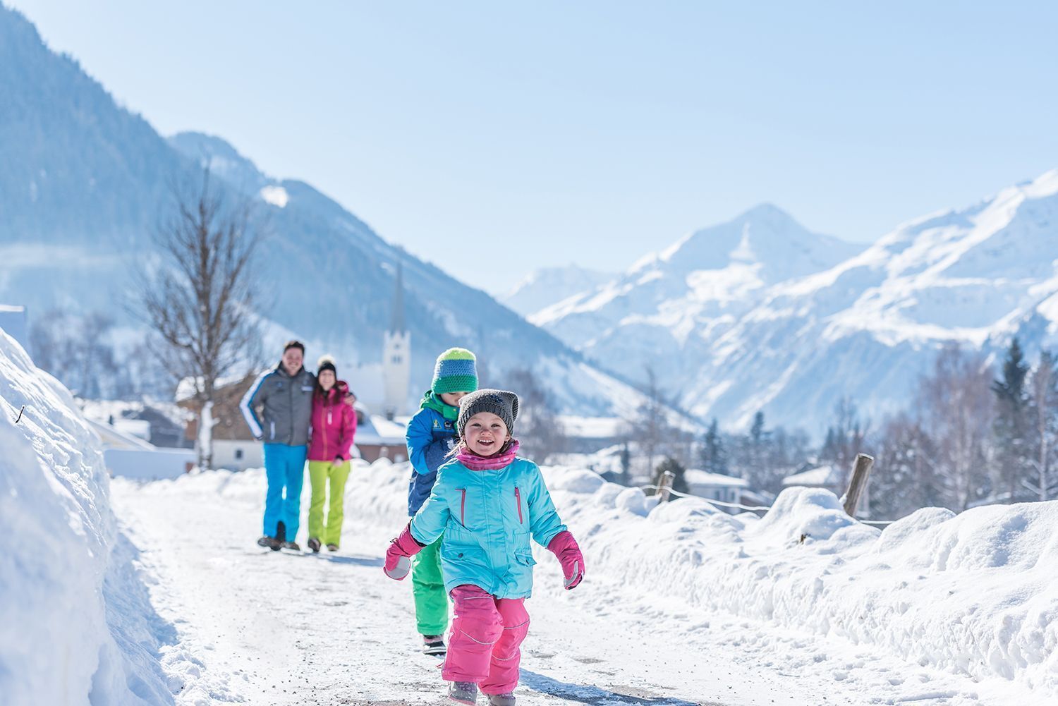Ein verschneiter Bergpfad, eine Familie geht spazieren.