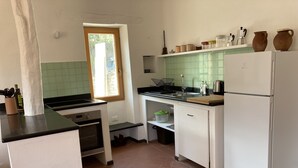 Une cuisine de taille réduite équipée d’une cuisinière, d’un four, d’un évier et d’un réfrigérateur.