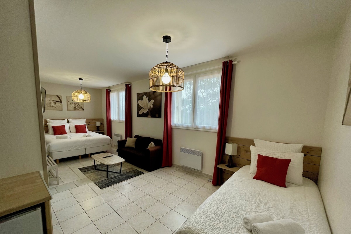 Une chambre d’hôtel avec deux lits, un canapé, une petite table et un radiateur.