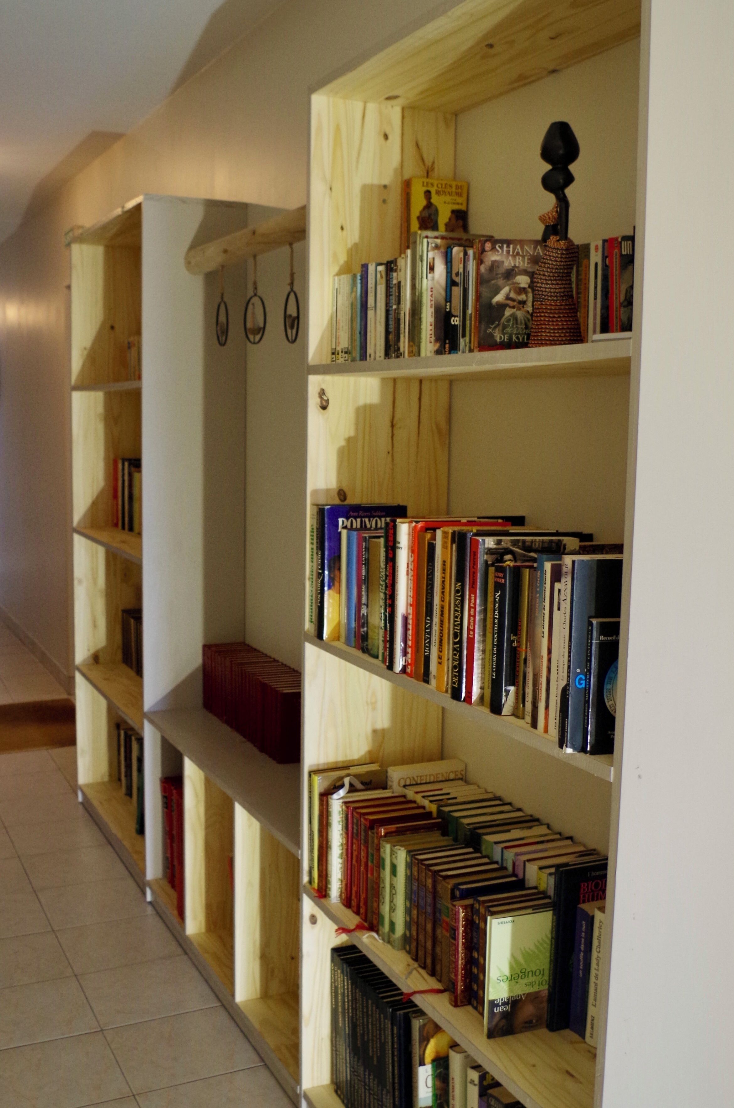 A row of wooden bookshelves filled with books, some with visible titles.