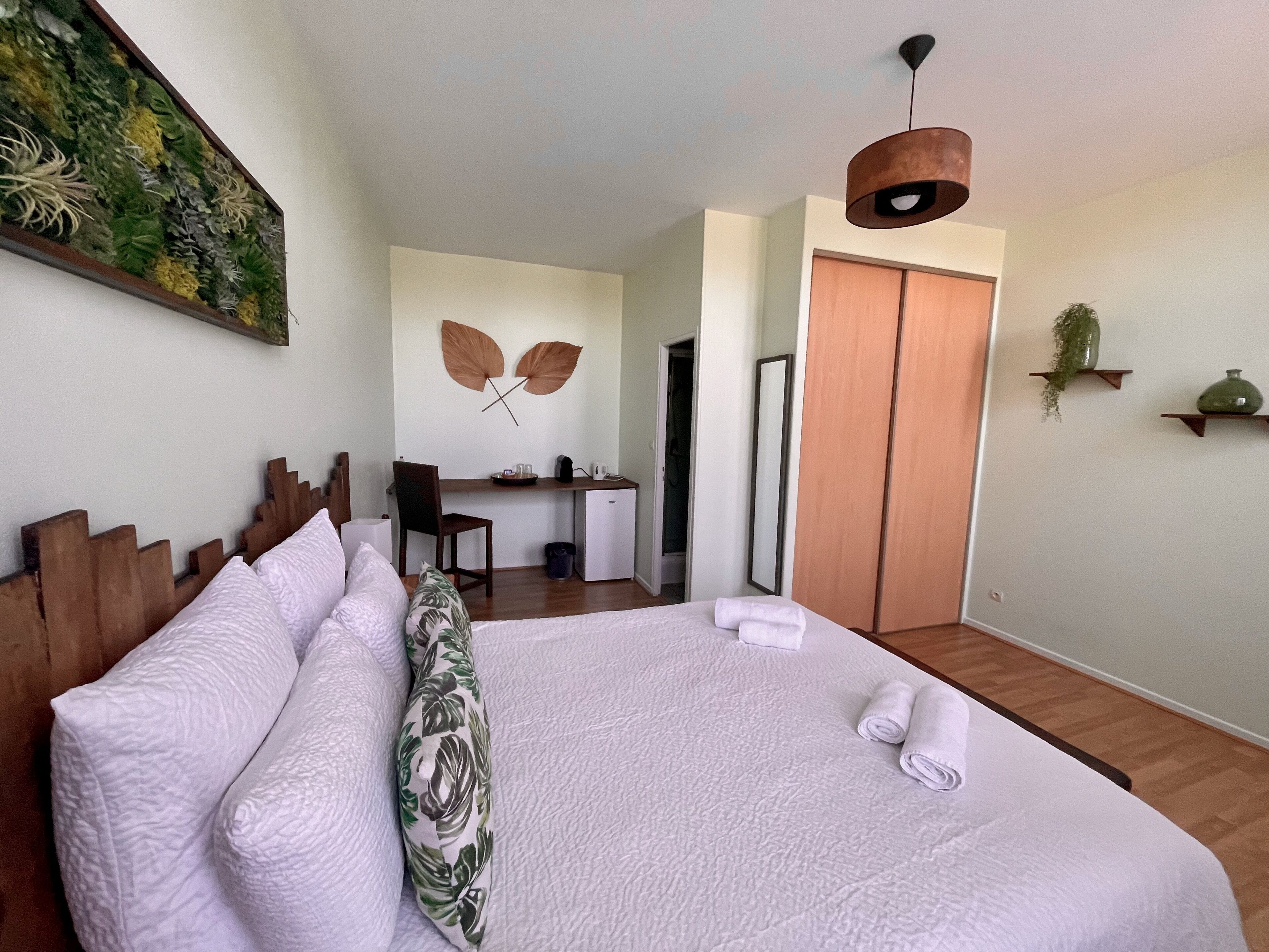 Una habitación de hotel ordenada con cama, escritorio y armario.
