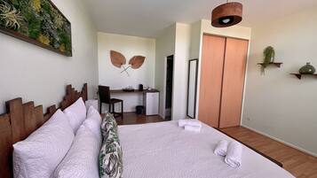 Una habitación de hotel ordenada con cama, escritorio y armario.
