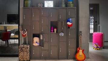 Una habitación con un armario grande, una guitarra y una maleta rosa.