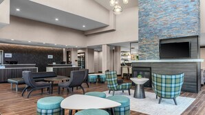 A modern lobby with a reception desk, seating area, and a fireplace. - Residence Inn by Marriott Detroit Sterling Heights (Clinton Township)