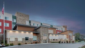 A multi-story hotel with a stone facade, a flagpole, and a paved entrance area. - Residence Inn by Marriott Detroit Sterling Heights (Clinton Township)