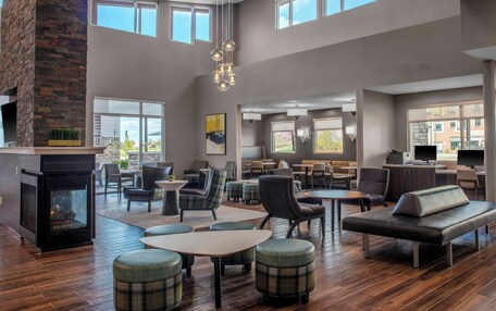 A spacious lounge area with multiple seating options, a fireplace, and large windows providing natural light.