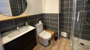 A modern bathroom with a sink, toilet, and shower. - 6/8 pers apartment in the heart of the Chartreuse at the foot of the ski slopes (Sarcenas)