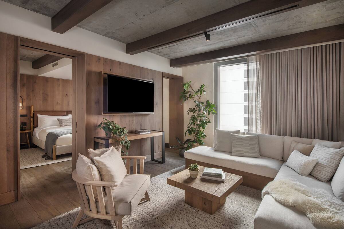Ein modernes Wohnzimmer mit einer Couch, einem Sessel, einem Couchtisch und einem Fernseher.