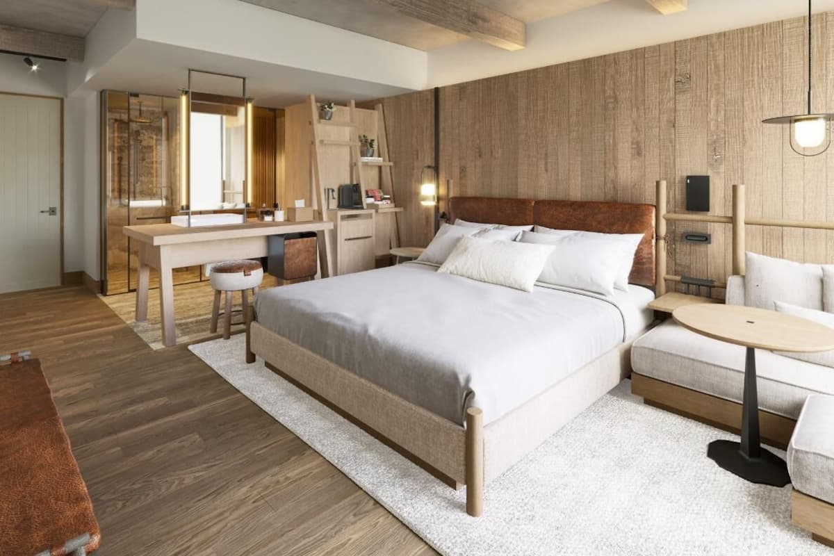 Ein modernes Schlafzimmer mit einem großen Bett, Nachttischen, einem Schreibtisch und einem Kleiderschrank.
