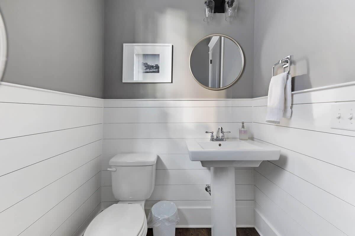 Une petite salle de bain comprenant des toilettes, un lavabo et un miroir.