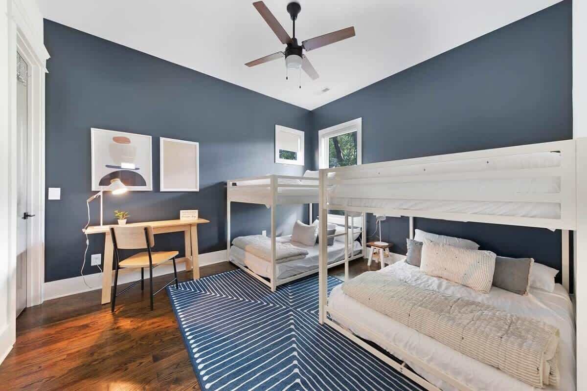 Une chambre avec un lit superposé, un bureau et une chaise.