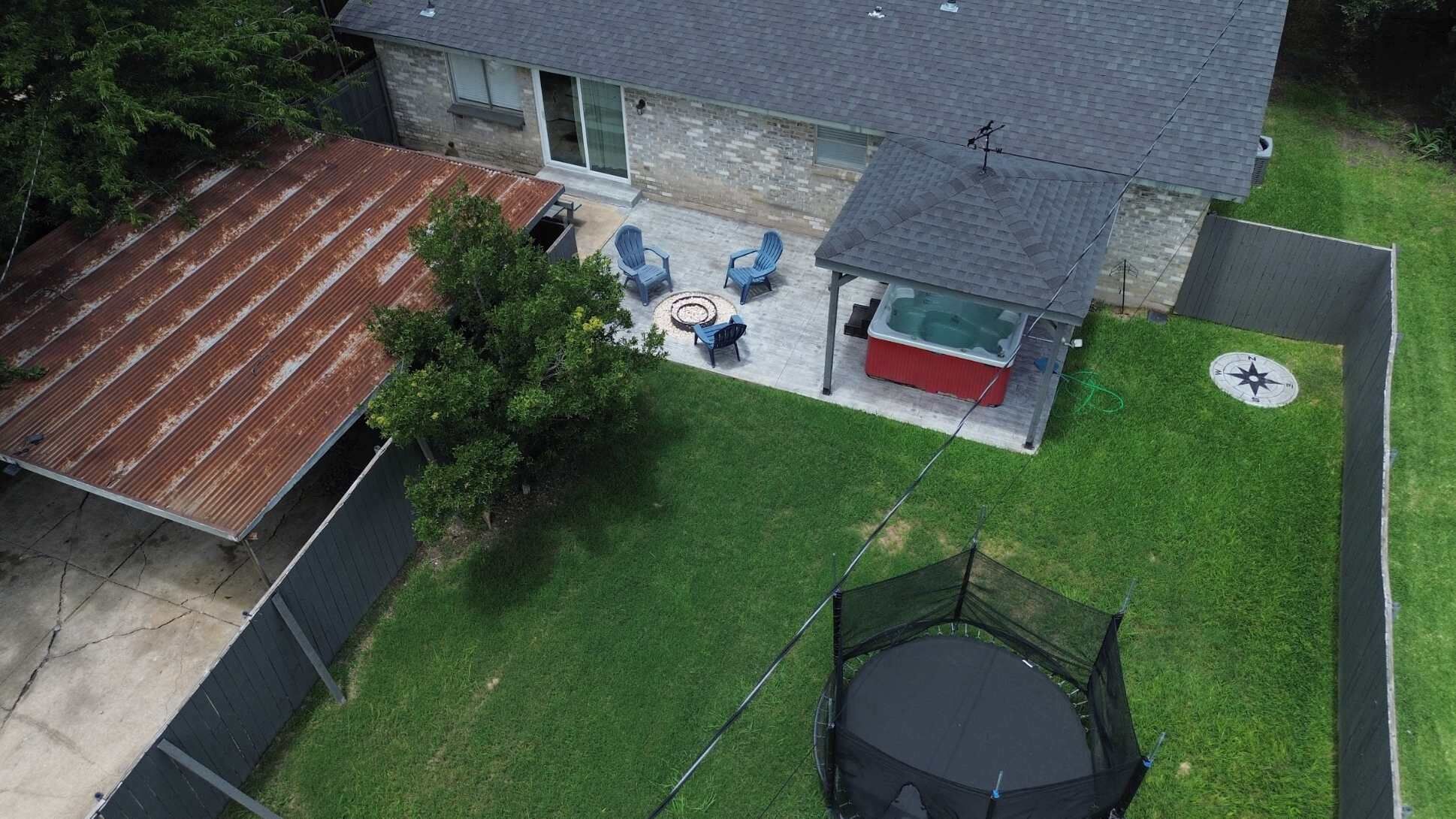 Une maison à deux étages dotée d’une terrasse, d’un jacuzzi et d’un trampoline.