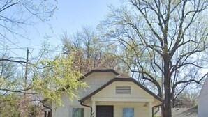 A single-story house with a front door, a small porch, and a pathway leading to the entrance. - KC Tiny Studio (Kansas City)