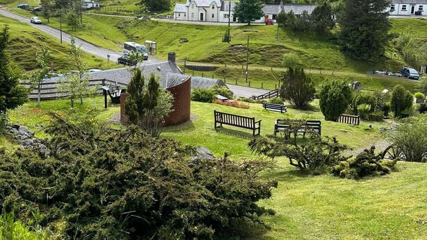 A rural landscape with a white house, a small red building, and a road. - 3 Bedroom Miners Cottage - Wanlockhead D & G (Wanlockhead)