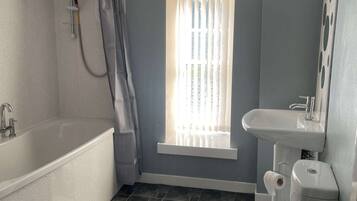 Tina con regadera, secadora de cabello, toallas