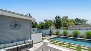 A backyard with a swimming pool, outdoor seating, and a decorative compass. - Private Saltwater Pool + Spacious Yard. King Suite and Linens & Towels Included! (Villas)