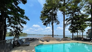 A pool area with lounge chairs and a view of a lake. - NEW Two Bedroom Lake Getaway! Serene and CLEAN! (Hot Springs)
