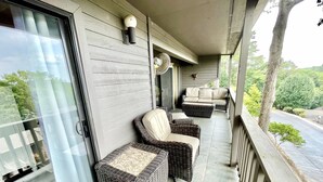 A covered porch with wicker furniture and a view of the surrounding greenery. - NEW Two Bedroom Lake Getaway! Serene and CLEAN! (Hot Springs)