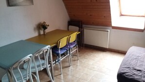 A small, cozy room with a dining table and chairs, a radiator, and a window. - 4-person apartment (Picherande)