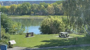 A park with a lake, benches, picnic tables, and a clear sky. - Fort Benton home with a fantastic view! (Fort Benton)