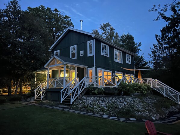 A two-story house with a porch, a chimney, and a well-maintained garden.