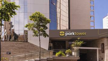 Entrada moderna de hotel com uma placa indicando 'Hotel Parktower'.