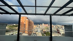 Um edifício alto com vista para um horizonte urbano através de uma fachada de vidro.