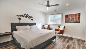 A bedroom with a bed, a ceiling fan, a window with blinds, a chair, and a wall-mounted artwork. - City Park - Walk to Main Street - Old Town (Park City)