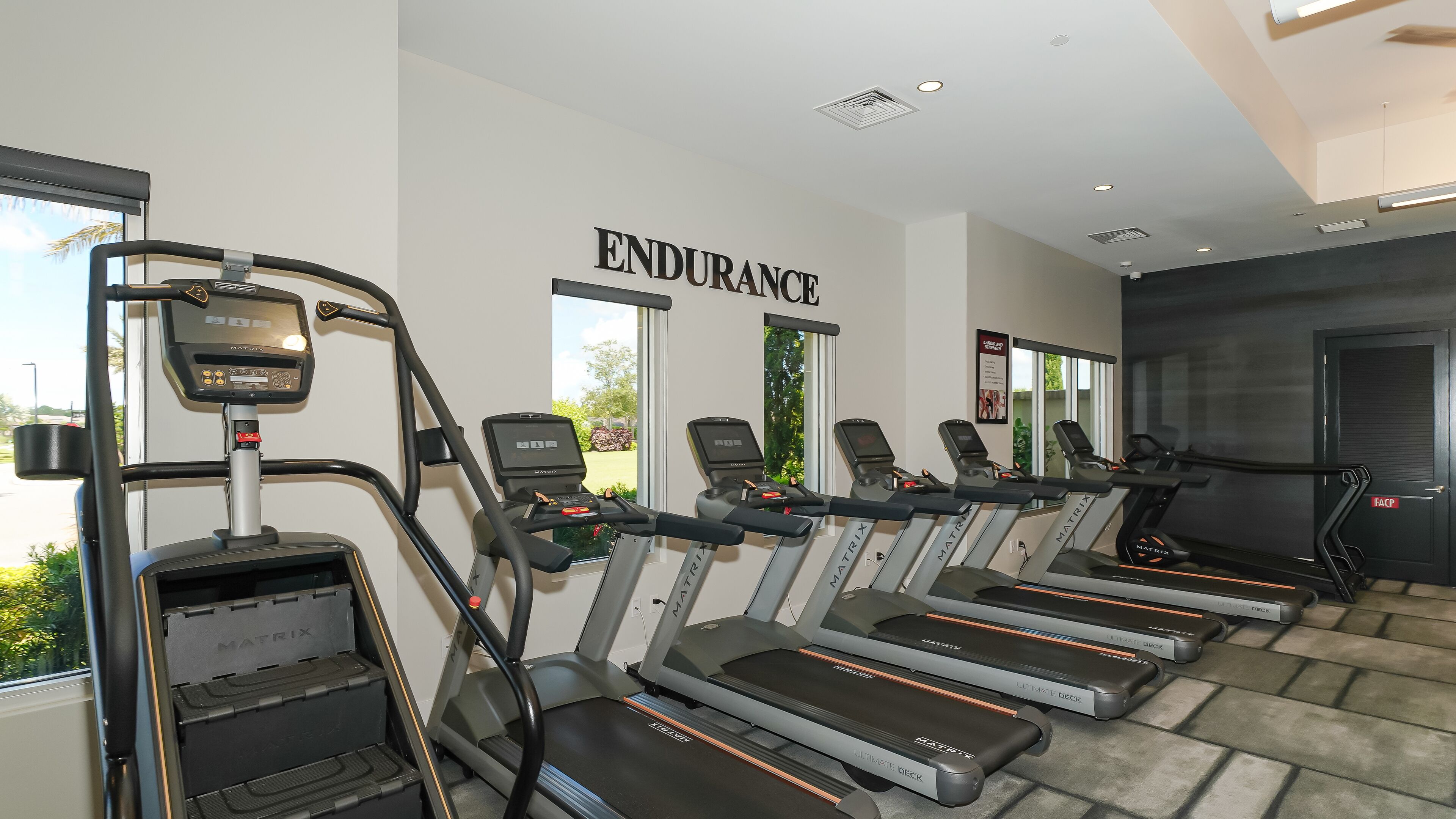 Une salle de sport équipée de tapis de course, d’un vélo d’appartement et d’un appareil d’aviron.
