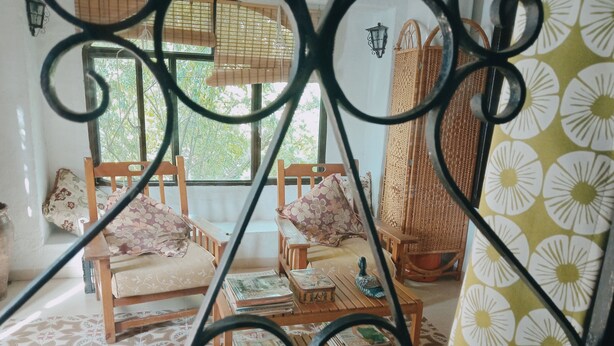 A room with two wooden chairs, a small table, and a patterned floor. - La Casita Verde Valle (Unknown)
