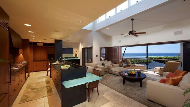 A spacious living area with a kitchen, a dining table, and a seating area with a view of the ocean. - Puunoa Beach Estates- Part OF Hyatt (LAHAINA)