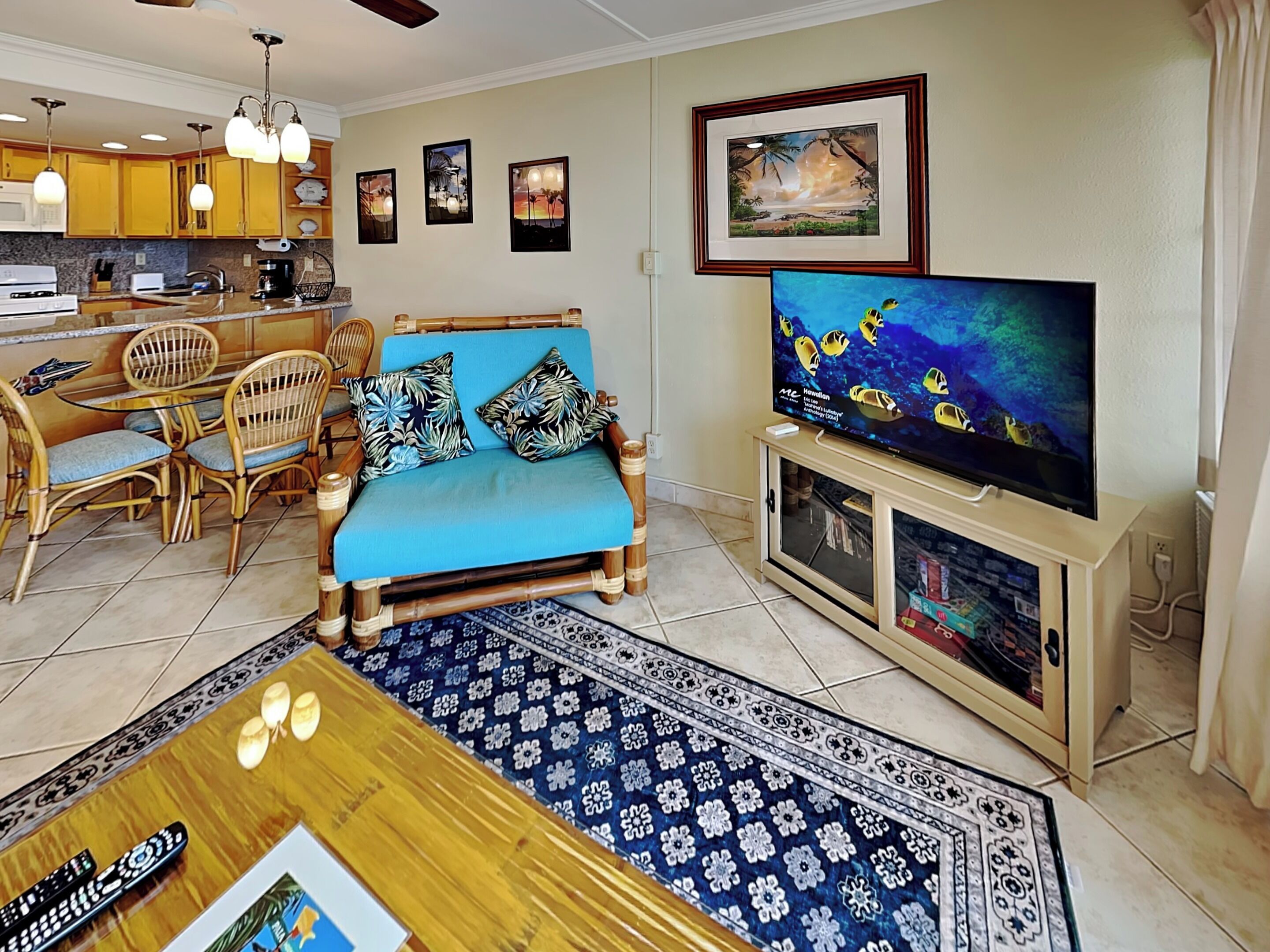 Una sala de estar con sofá, televisor, mesa de comedor y sillas.