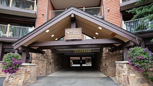 A building entrance with a sign reading "Sawmill Creek Condominiums." - Ski-in condo off 4 O'clock, 1 block to Main St, steps to Gondola (Breckenridge)